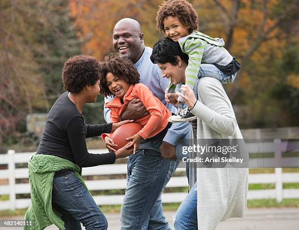 family playing football together outdoors - focus on sport 2013 stock pictures, royalty-free photos & images