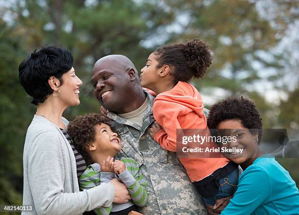 family greeting returning soldier outdoors - interracial wife photos stock pictures, royalty-free photos & images