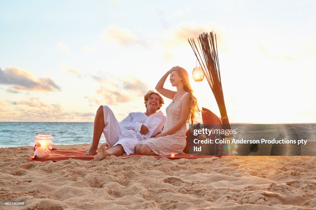 Caucasian couple relaxing on beach blanket