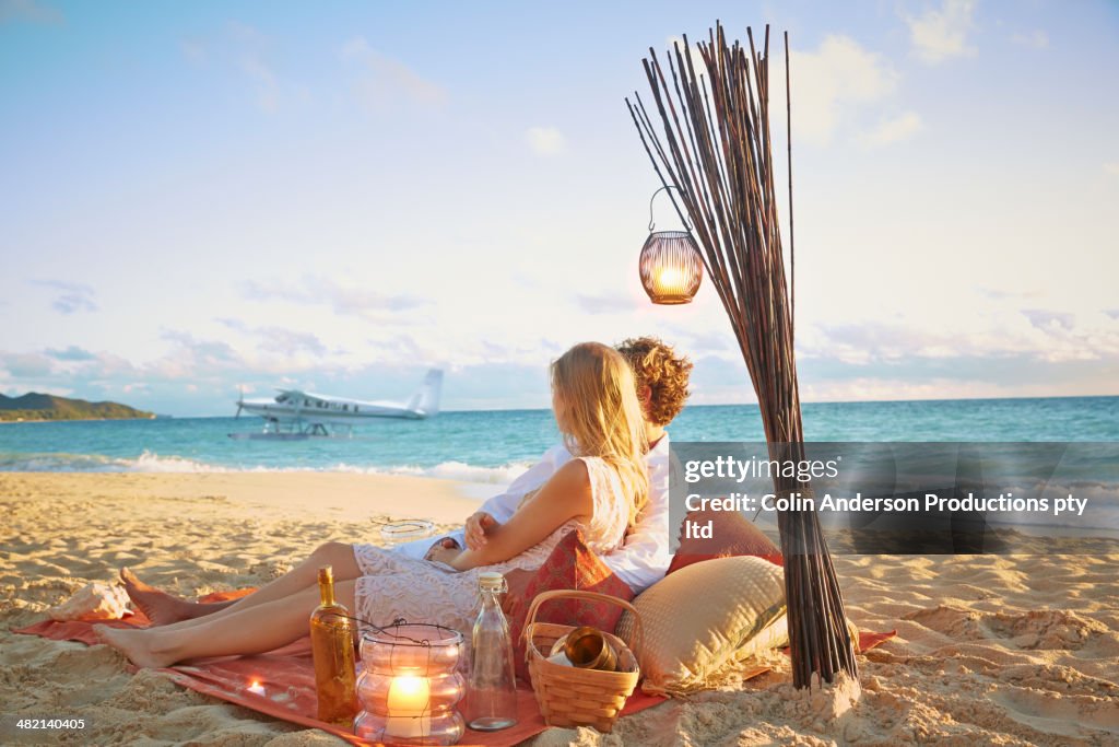 Caucasian couple relaxing on beach blanket