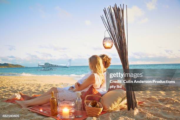 caucasian couple relaxing on beach blanket - plane crush stock pictures, royalty-free photos & images