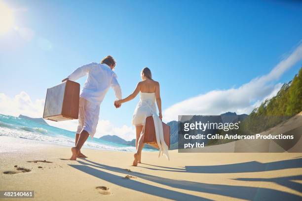 caucasian couple with suitcases on tropical beach - runaway groom stock pictures, royalty-free photos & images