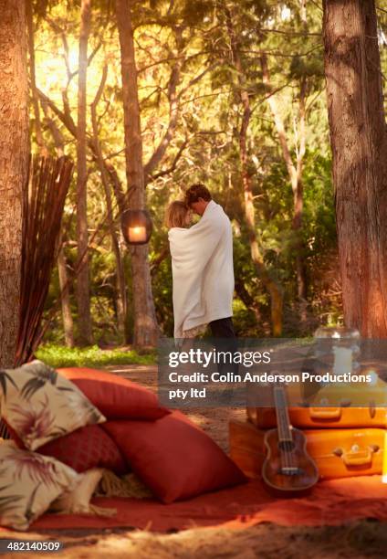 caucasian couple wrapped in blanket in forest - runaway groom stock pictures, royalty-free photos & images