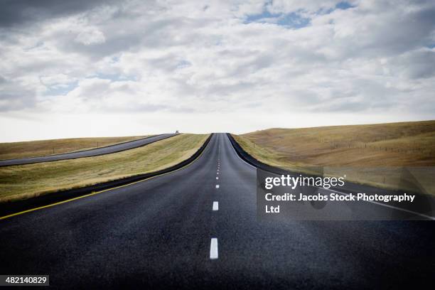 paved road through rural landscape - casper wyoming foto e immagini stock