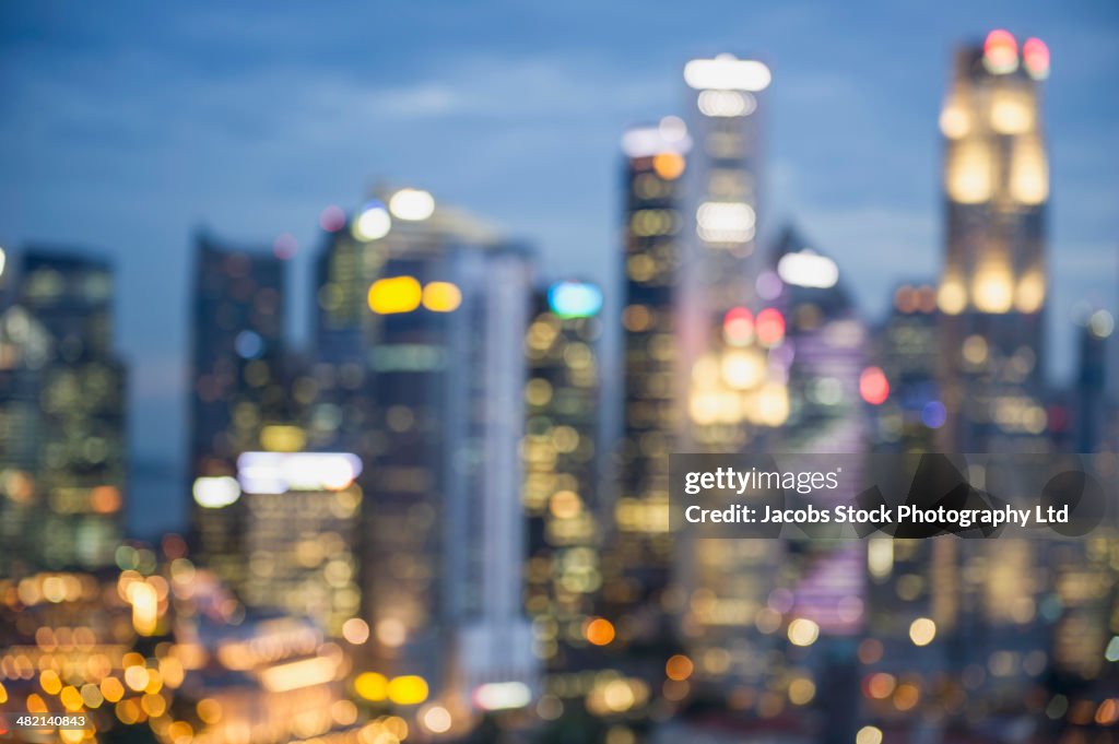 Blurred view of city skyline lit up at night, Singapore