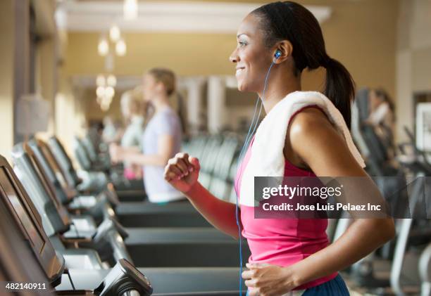 african american woman exercising on treadmill in gym - after workout towel happy stock pictures, royalty-free photos & images