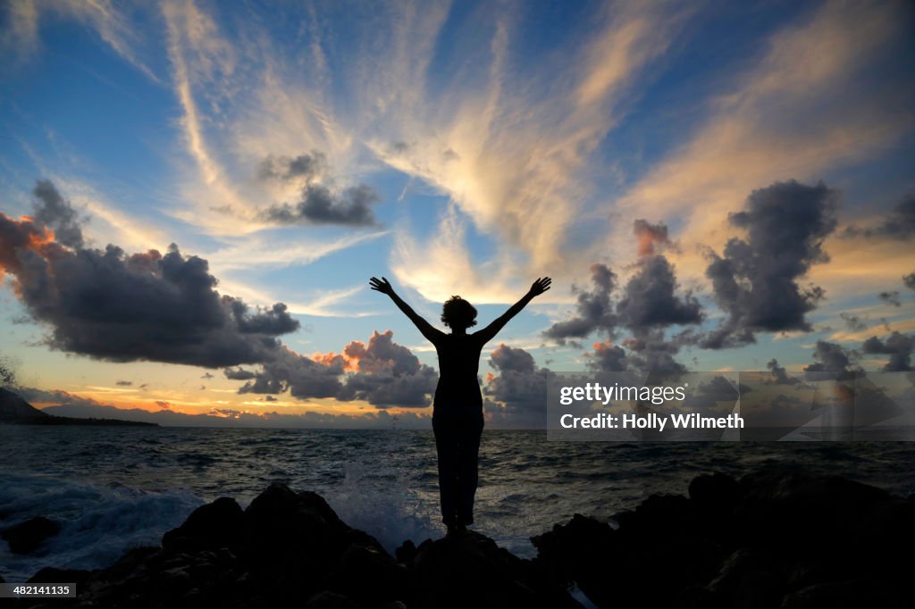 Silhouette of Caucasian woman on beach at sunset