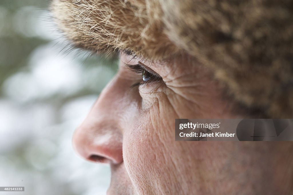Close up of Caucasian man wearing furry hat in snow
