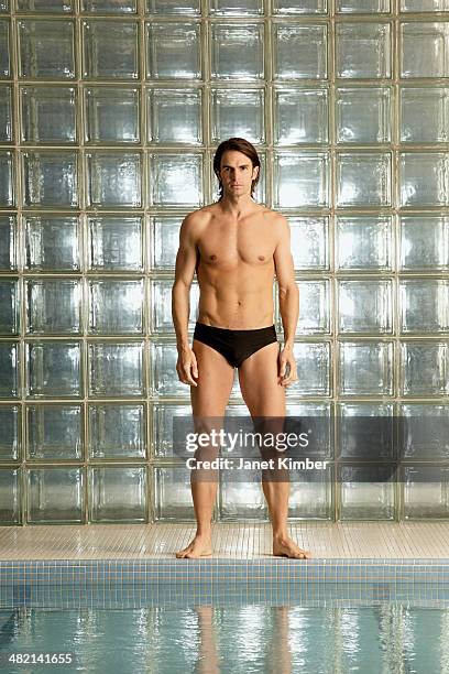 caucasian man standing by pool - slip de bain de compétition photos et images de collection