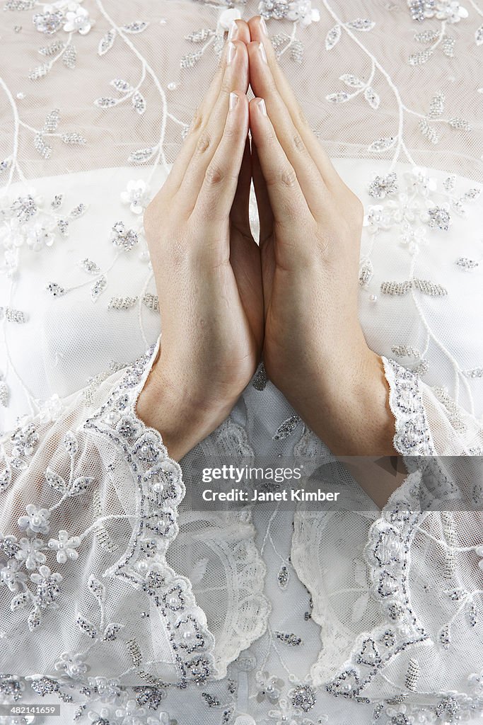 Mixed race bride's hands in prayer position