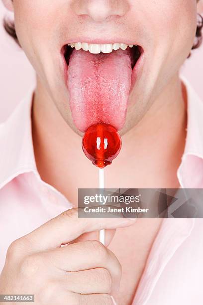 caucasian man licking lollipop - candy on tongue stock pictures, royalty-free photos & images
