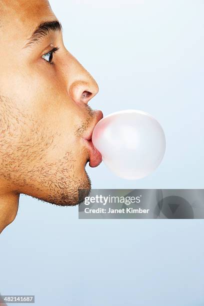 mixed race man blowing bubble with gum - bubble gum bubble stock pictures, royalty-free photos & images