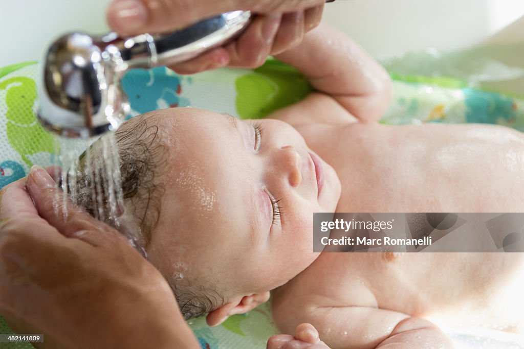 Caucasian mother giving baby boy a bath