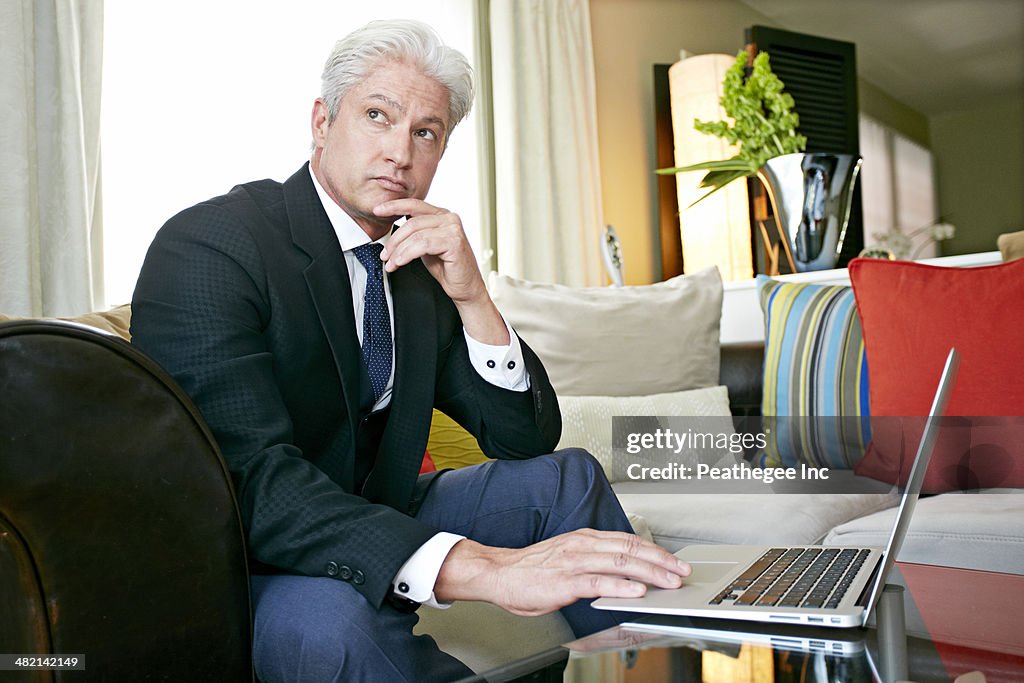 Caucasian businessman working in living room