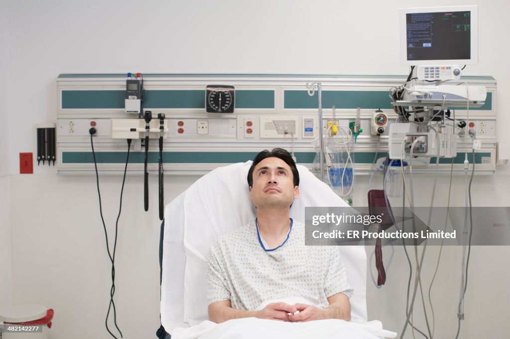 Hispanic man laying in hospital bed