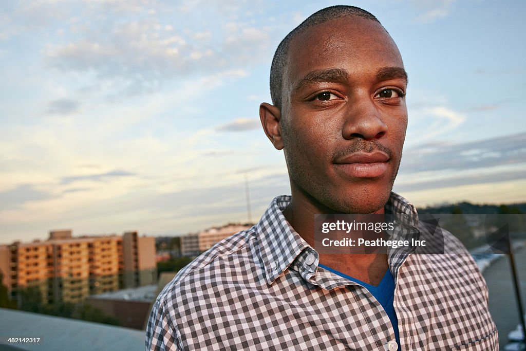 Black man standing on urban rooftop