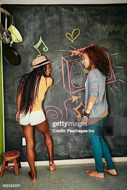 women drawing on blackboard wall - chalk wall stock pictures, royalty-free photos & images