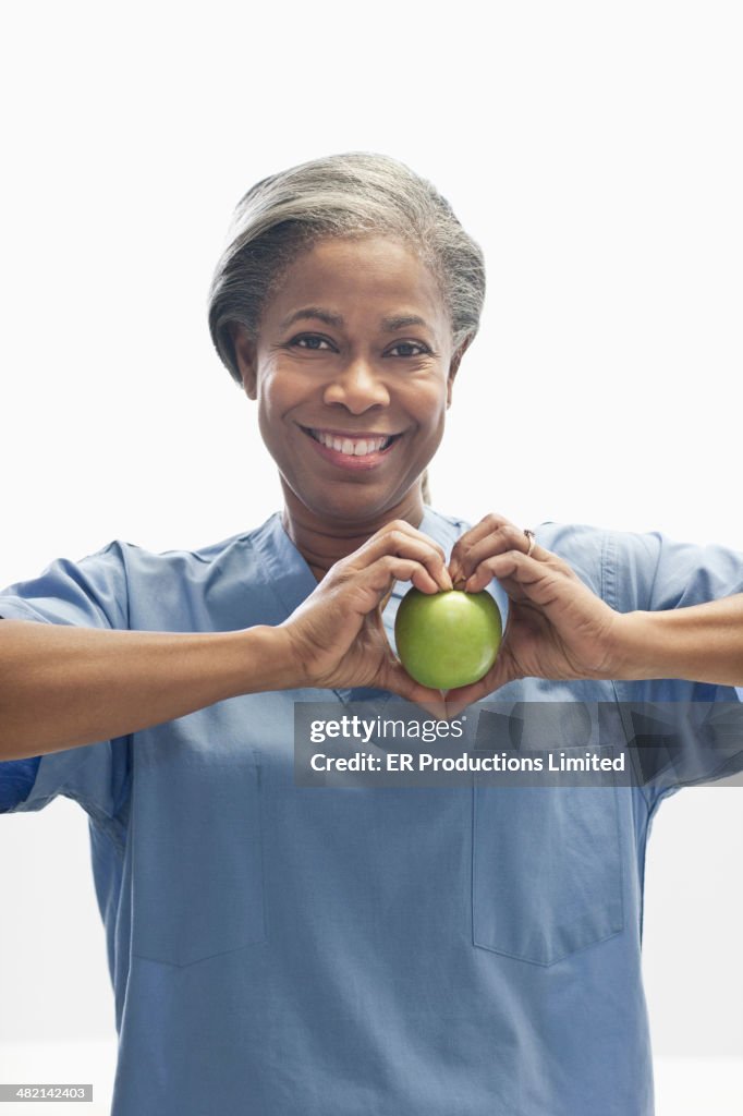 Woman holding apple in heart-shape