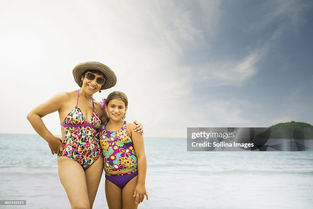 Mother and daughter smiling on beach