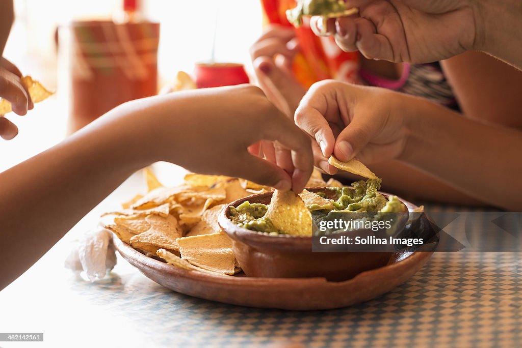 Children eating chips and guacamole