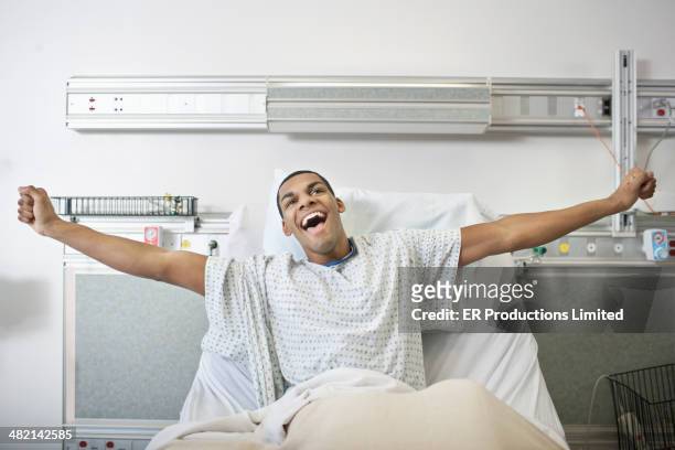 man cheering in hospital bed - injured man in hospital bed stockfoto's en -beelden