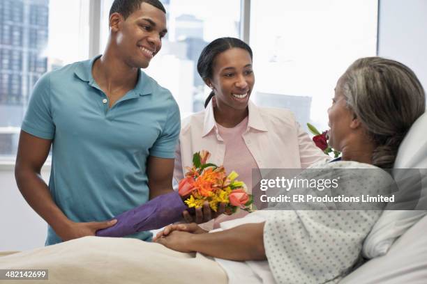 children bringing mother flowers in hospital - er visit stock pictures, royalty-free photos & images