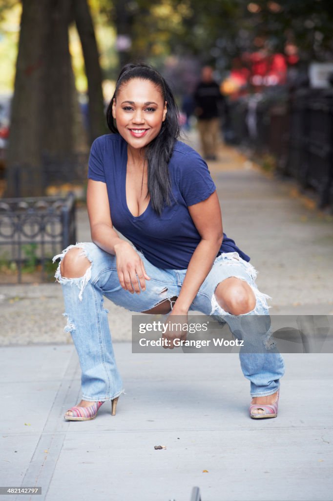 Mixed race woman posing on urban sidewalk