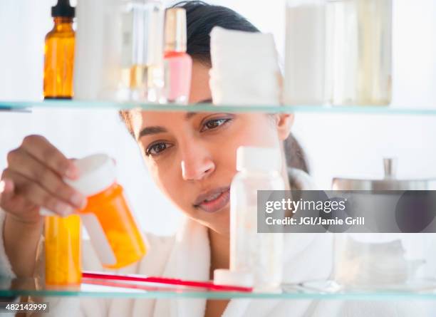 close up of asian woman examining label of prescription bottle - armário de banheiro - fotografias e filmes do acervo