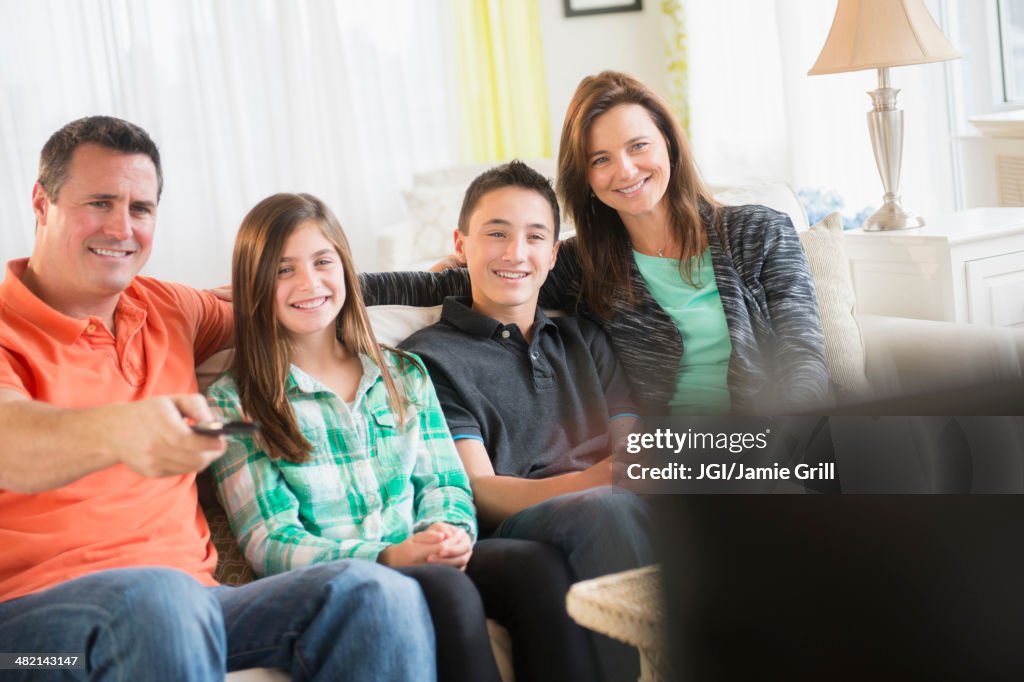 Caucasian family watching TV in living room