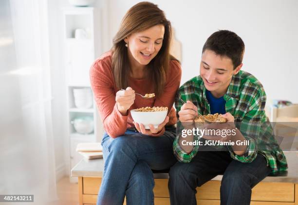 caucasian mother and son eating cereal together - teenagers eating with mum stock pictures, royalty-free photos & images