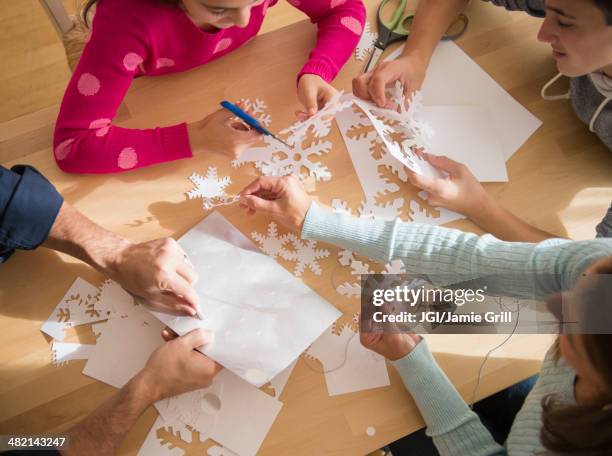 caucasian family cutting out paper snowflakes - paper snowflakes stock-fotos und bilder