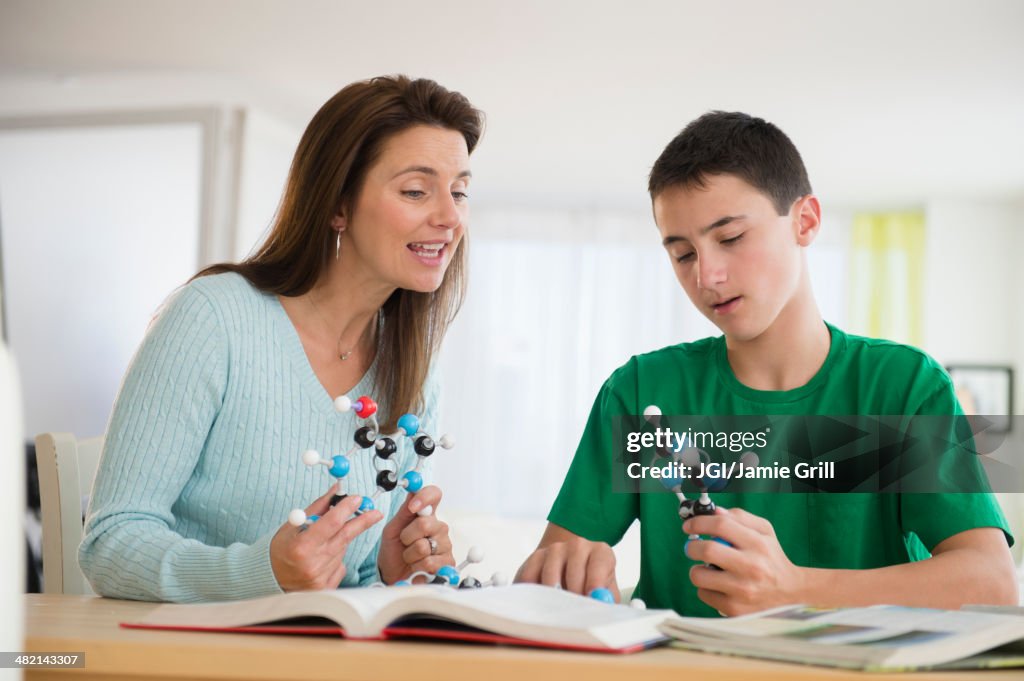 Caucasian mother and son studying atom models