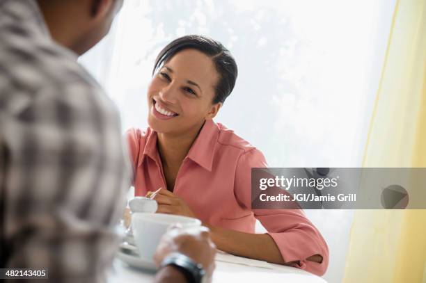 happy couple drinking coffee - sunlit cafe male stock pictures, royalty-free photos & images