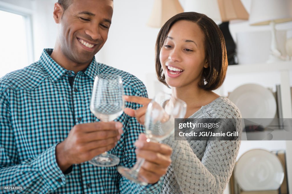 Happy couple shopping for wine glasses