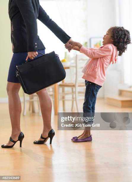 black mother pulling anxious daughter - man and woman holding hands profile stock-fotos und bilder