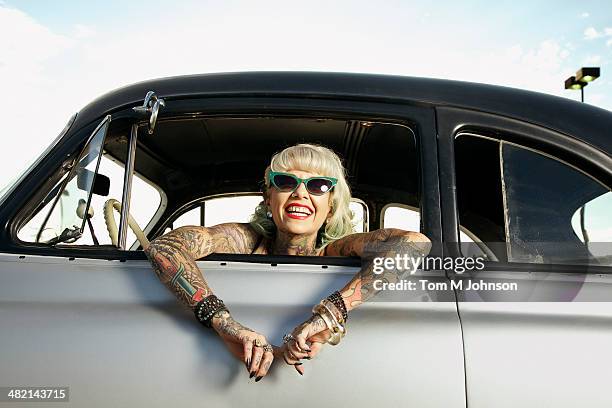 woman with tattoos leaning out window of 1951 chevy - cool cars ストックフォトと画像