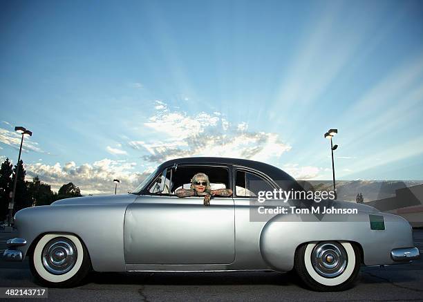 woman with tattoos leaning out window of 1951 chevy - 1950s america stock pictures, royalty-free photos & images