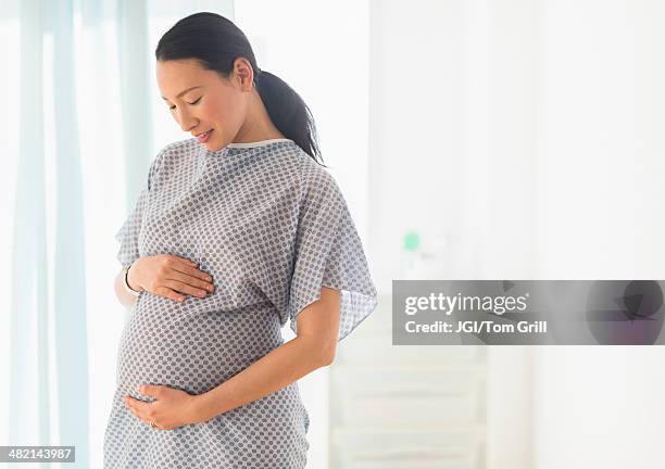 pregnant japanese woman in hospital gown - hospital gown stock-fotos und bilder