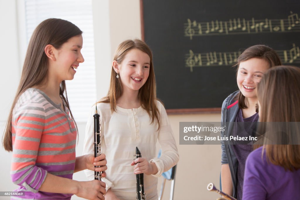 Caucasian girls talking in music class