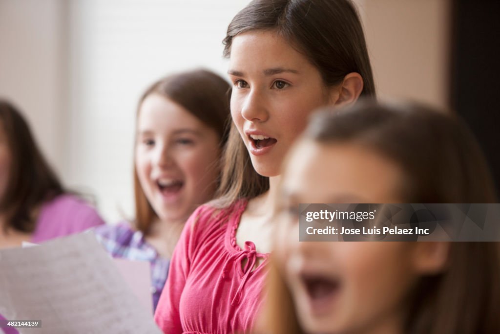 Caucasian girls singing in music class