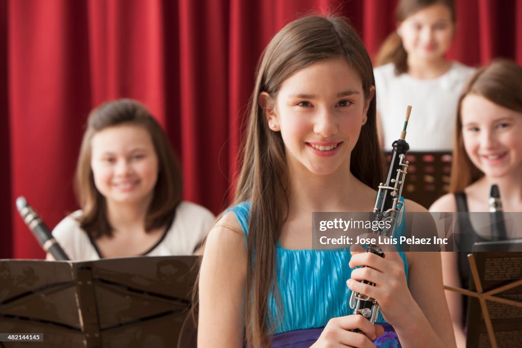 Portrait of smiling Caucasian girls with musical instruments on stage