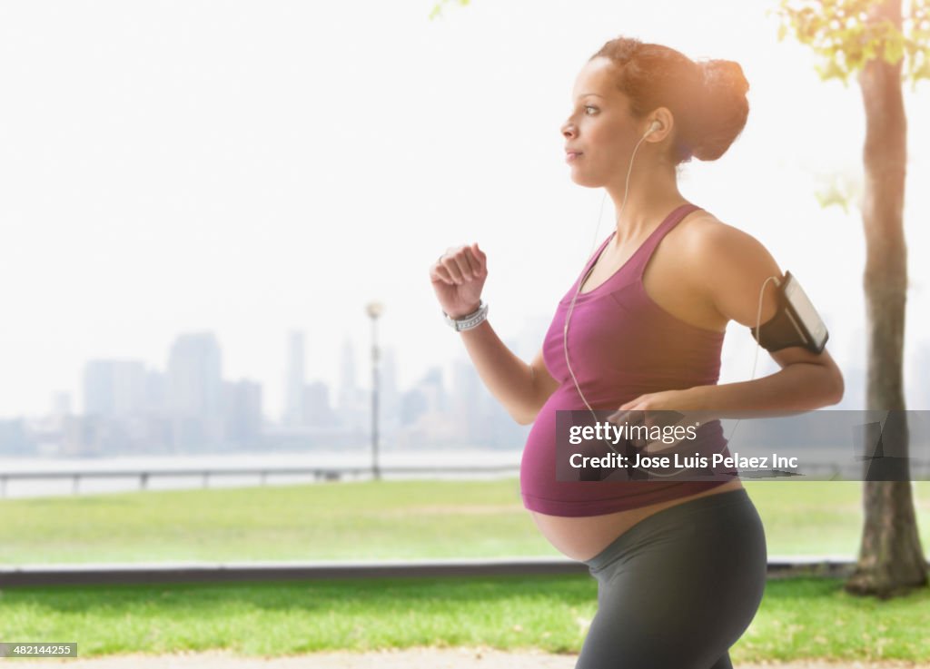 Pregnant mixed race woman power walking in park