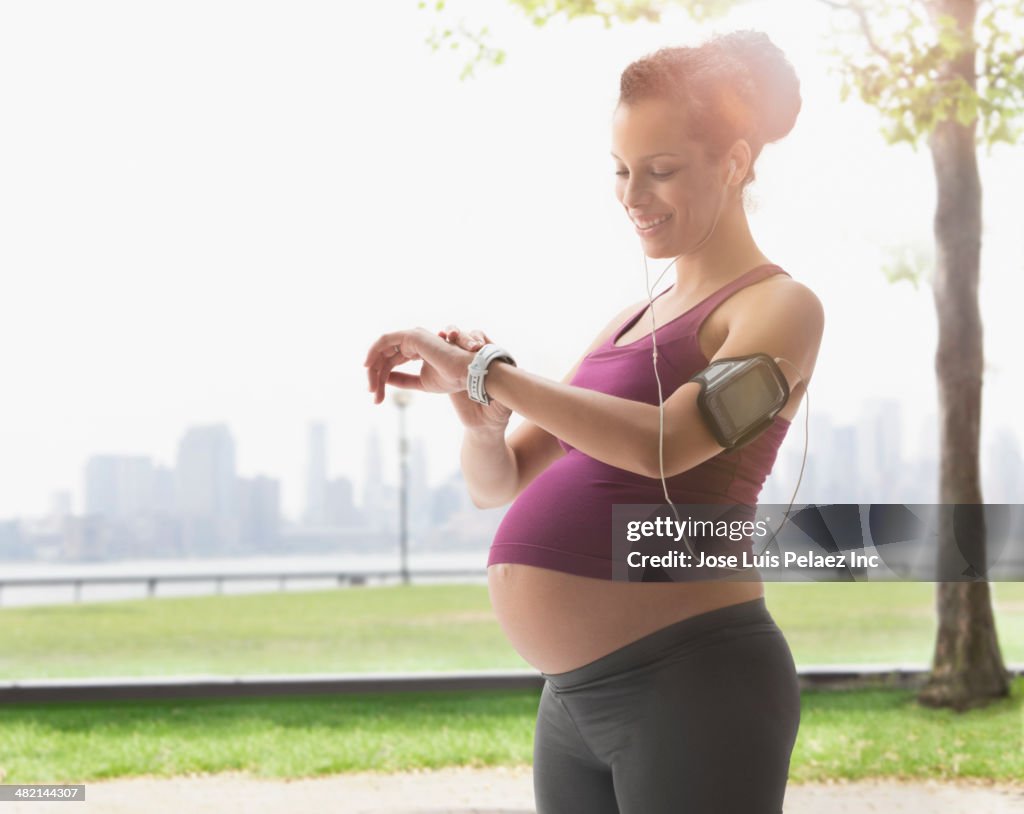 Pregnant mixed race woman exercising in park