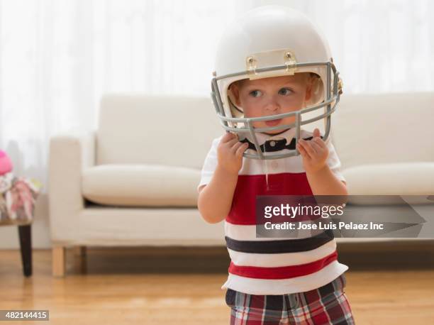 caucasian boy wearing football helmet - safety american football player stockfoto's en -beelden