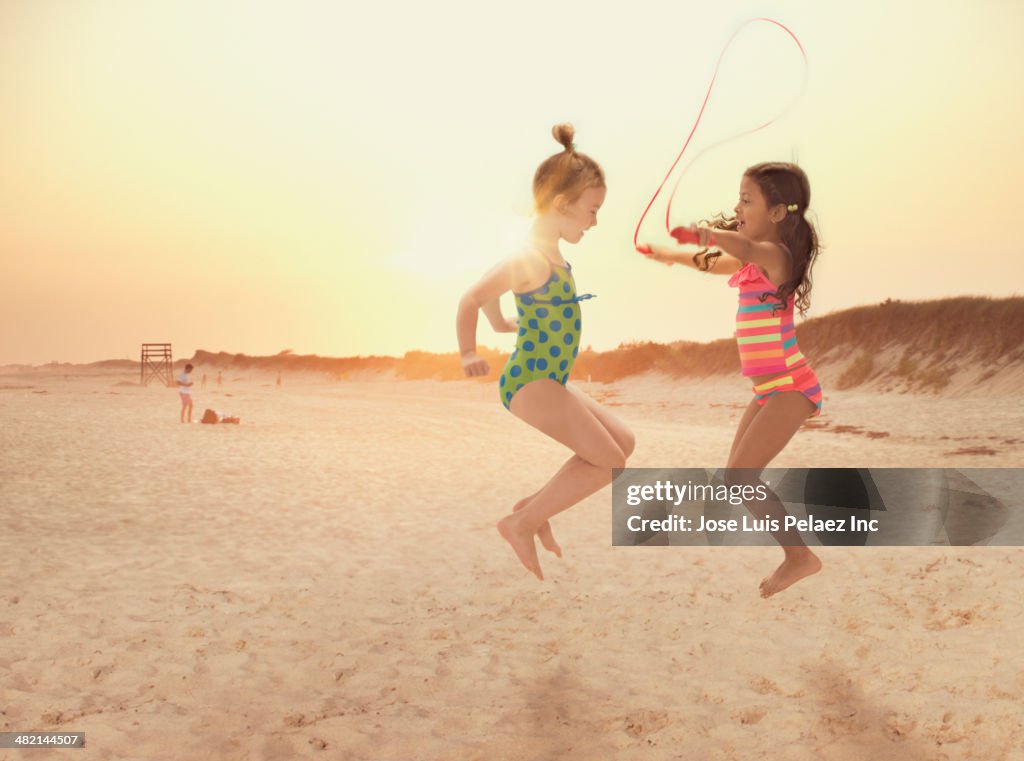 Girls jumping rope on beach