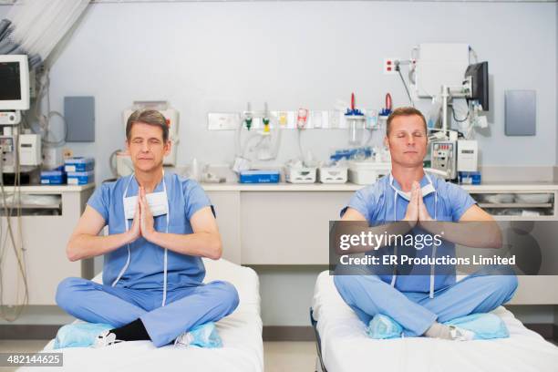 caucasian surgeons meditating on hospital beds - nurse meditating stock pictures, royalty-free photos & images