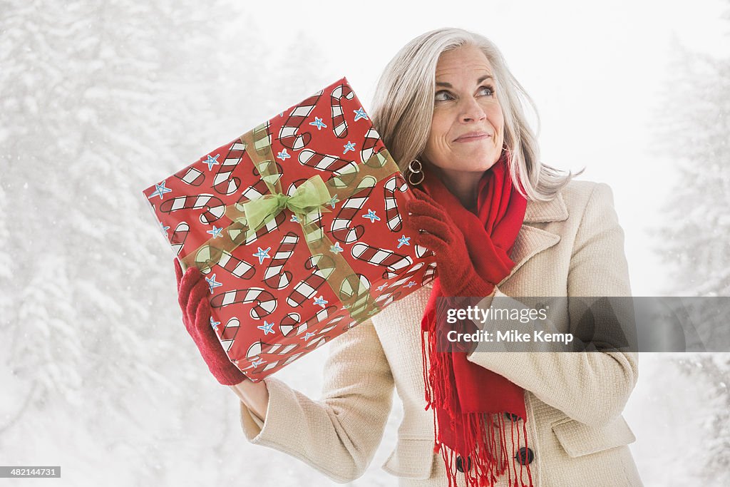 Caucasian woman shaking Christmas gift