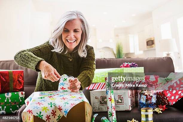 caucasian woman wrapping christmas gifts - cut out happy ストックフォトと画像