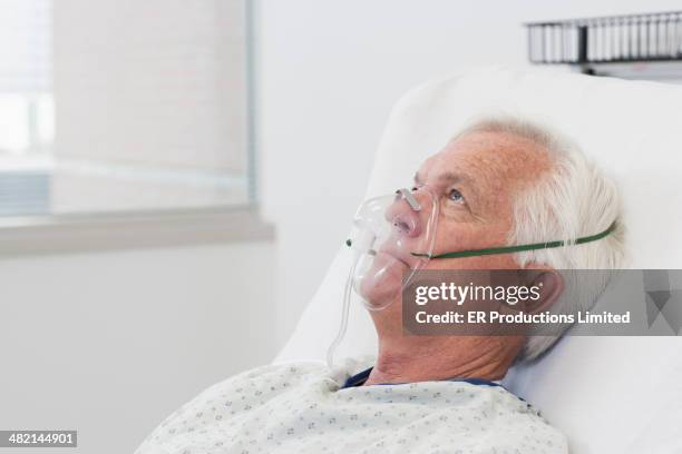 man wearing oxygen mask in hospital bed - apparecchio per la respirazione foto e immagini stock