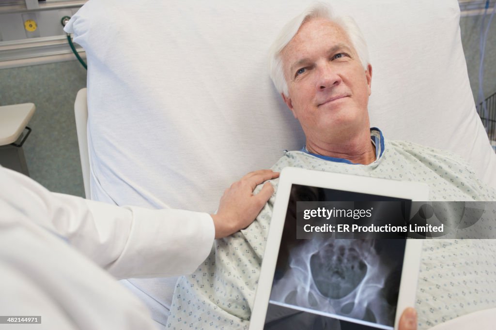 Doctor showing patient x-rays on digital tablet